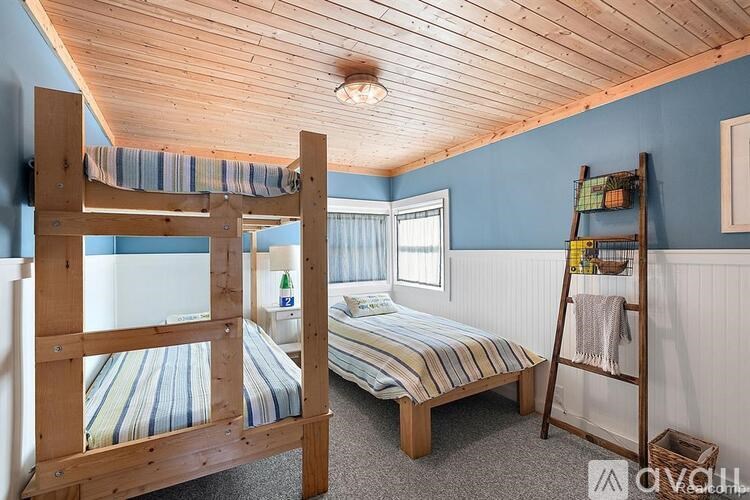 A room with two beds and a ladder.