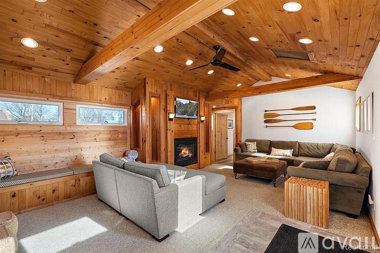 A living room with a grey couch and a fireplace.
