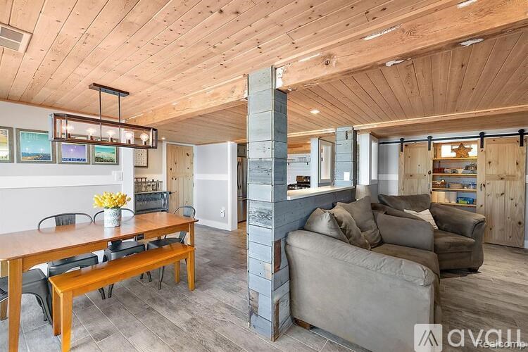 A living room with a couch, a table, and a refrigerator.