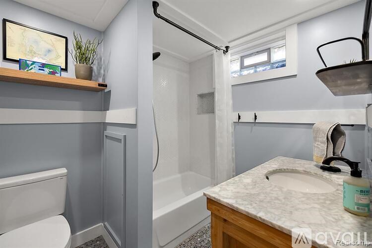 A bathroom with a toilet, sink, and shower.