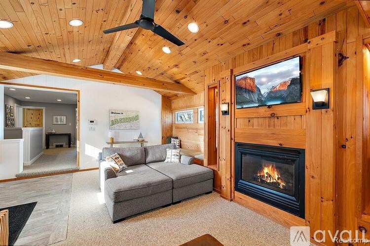 A living room with a fireplace and a painting of a mountain scene on the wall.