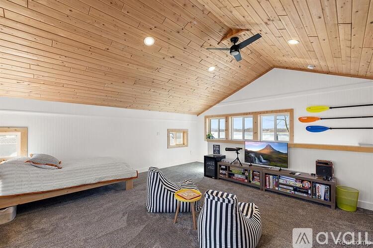 A bedroom with a wooden ceiling and a bed.