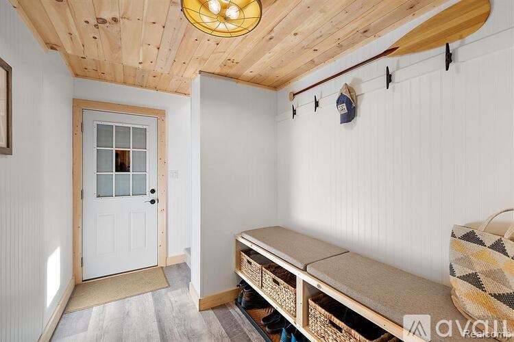 A room with a white door and a wooden ceiling.