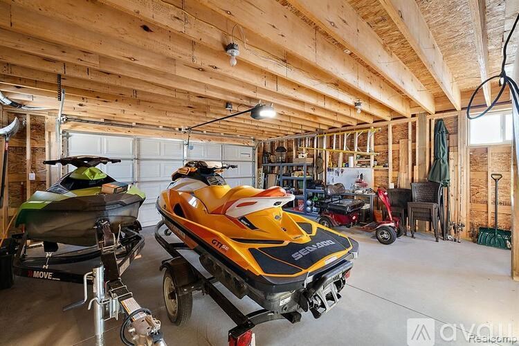 A yellow and black jet ski is parked in a garage.