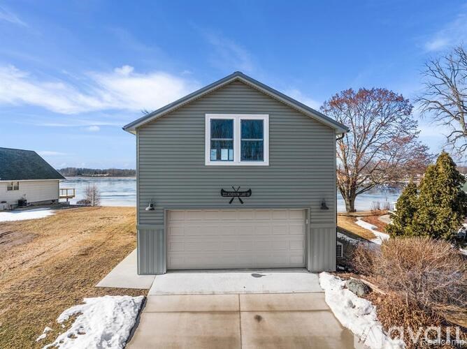 A house with a grey exterior and a white window is shown with a clear blue sky in the background.