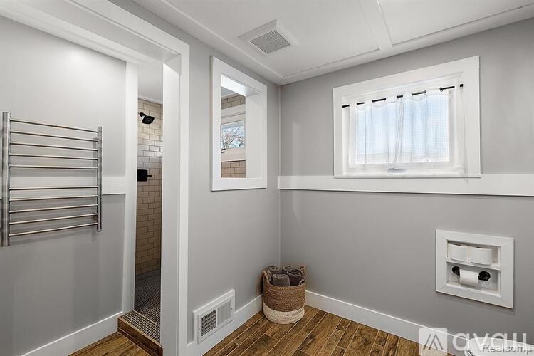 A bathroom with a towel rack and a window.