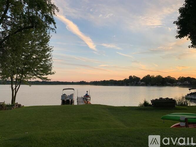 A serene lakeside scene with boats docked and a clear sky.