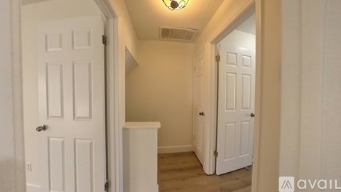 A hallway with two doors and a light on the ceiling.