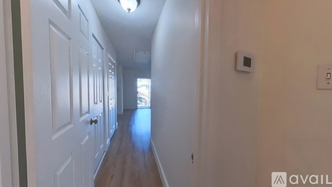 A long hallway with white doors and a light on the wall.