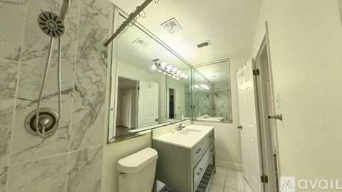 A bathroom with a marble shower and a white sink.