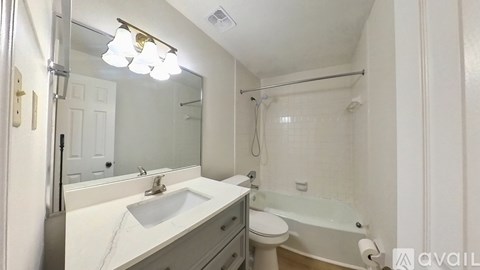 A bathroom with a sink, toilet, and bathtub.