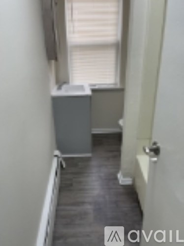 A room with a grey cabinet and a window with blinds.