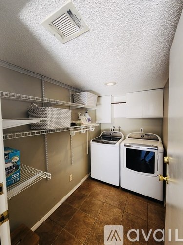 A small kitchen with white appliances and a white door.