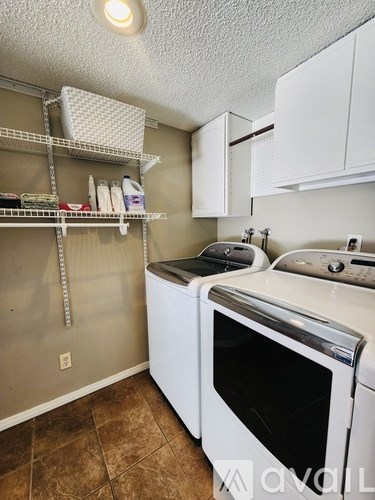 A kitchen with a white oven and brown tiles.