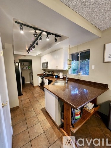 A kitchen with a brown counter top and white cabinets.