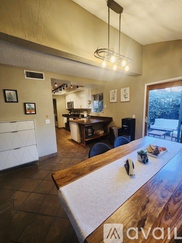 A kitchen with a wooden table and chairs in the foreground.