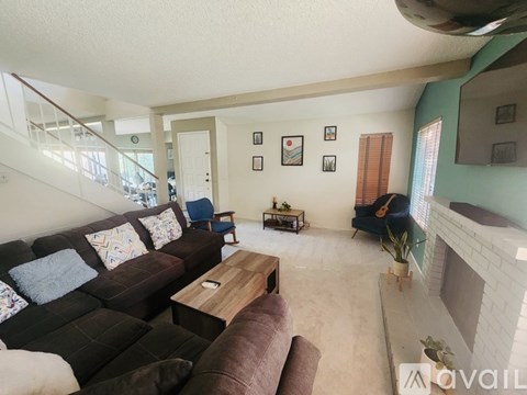 A living room with a brown couch and a wooden coffee table.