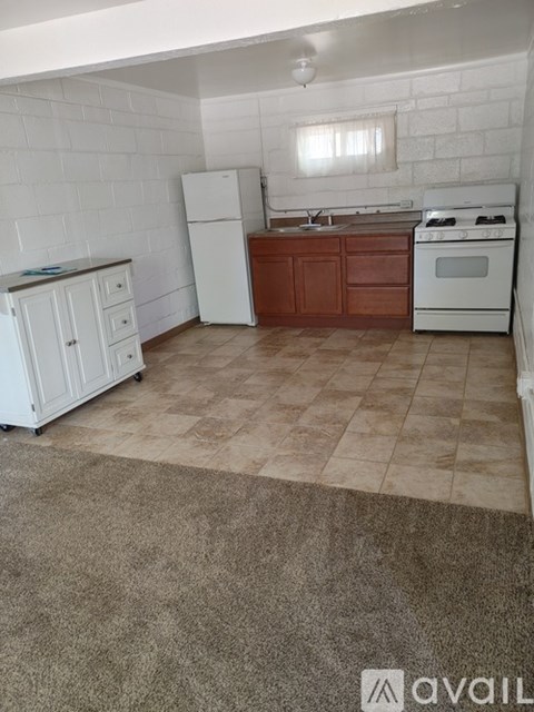 A kitchen with white appliances and brown cabinets.