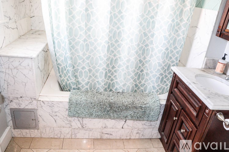 A bathroom with a marble bench and a shower curtain.