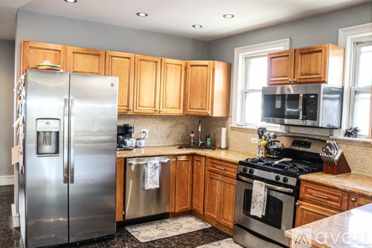 A kitchen with wooden cabinets and a stainless steel refrigerator.