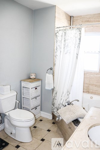 A white toilet sits next to a white sink in a bathroom.