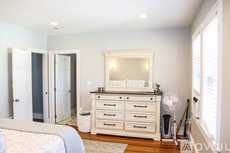 A baby's room with a white crib and a dresser with a mirror above it.