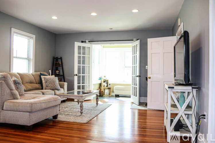 A living room with a couch, a coffee table, and a television.