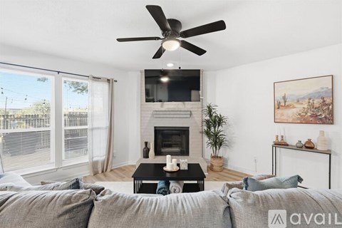A living room with a grey couch and a fireplace.