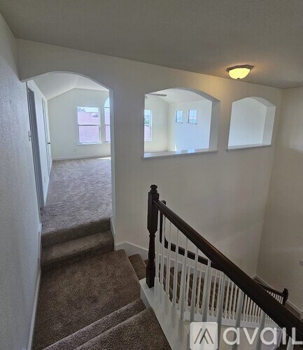 A hallway with a staircase leading to a second floor.