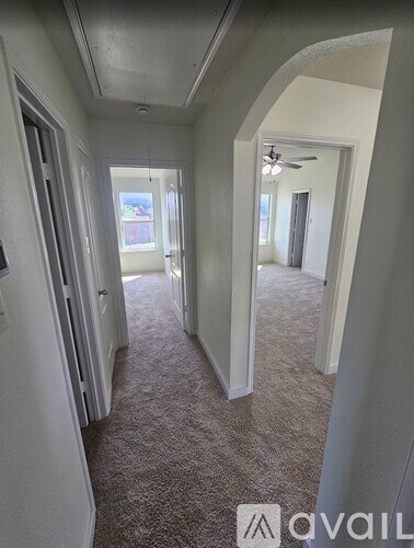 A hallway with carpeted floors and white walls.
