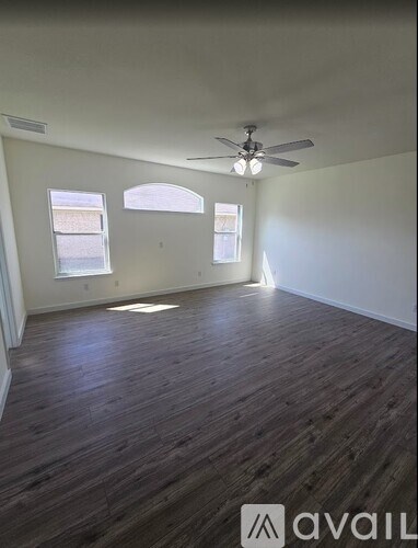 A room with wooden flooring and a ceiling fan.