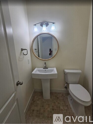 A small bathroom with a toilet, sink and mirror.