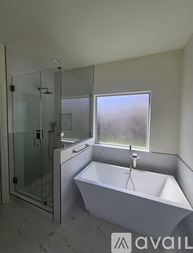 A bathroom with a white tub and a glass shower.