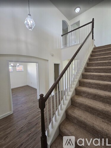 A staircase with a carpeted runner and a wooden banister.