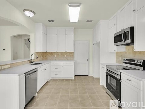 A kitchen with white cabinets and appliances.