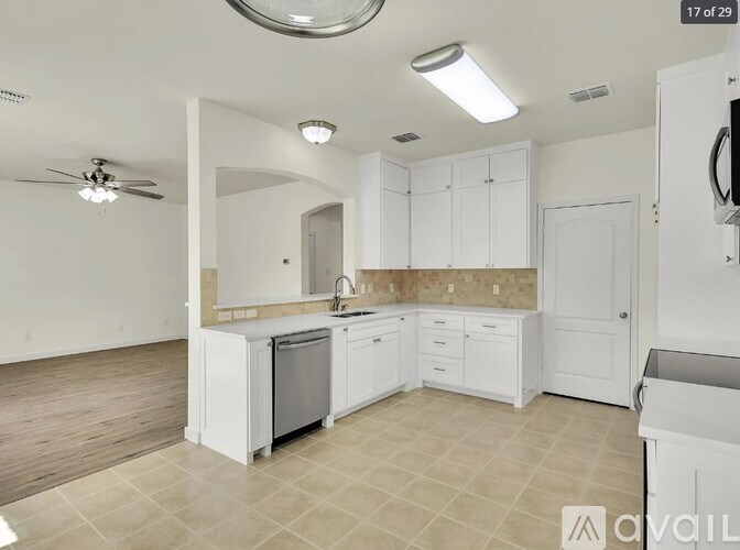 A kitchen with white cabinets and a tiled floor.