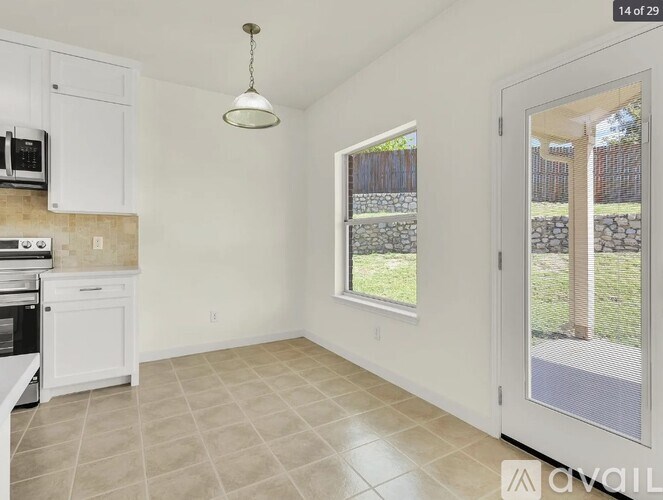 A kitchen with white cabinets and a microwave above the stove.
