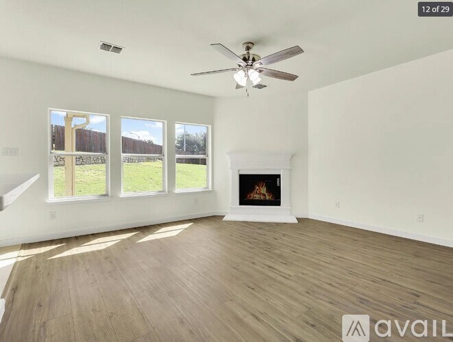 A spacious room with a fireplace and a ceiling fan.