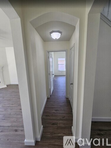 A long hallway with arched ceilings and wooden floors.