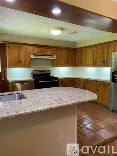 A kitchen with wooden cabinets and a granite countertop.