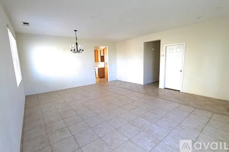 A room with a chandelier, a door, and a window.