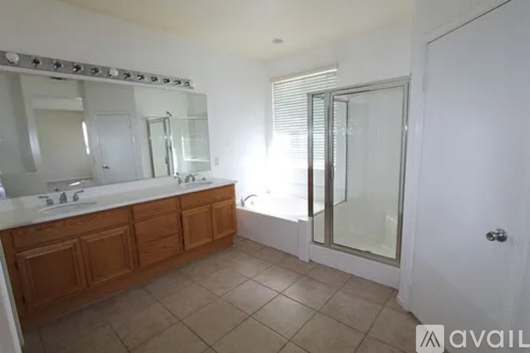 A bathroom with a white sink and a large mirror.