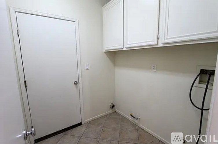 A white door is in a room with white walls and a tile floor.