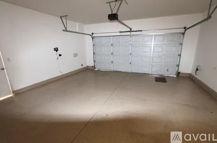 A spacious garage with a white door and a concrete floor.