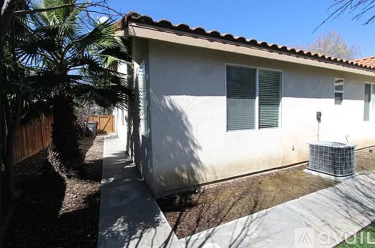 A house with a brown roof and a white wall with a window and a door.