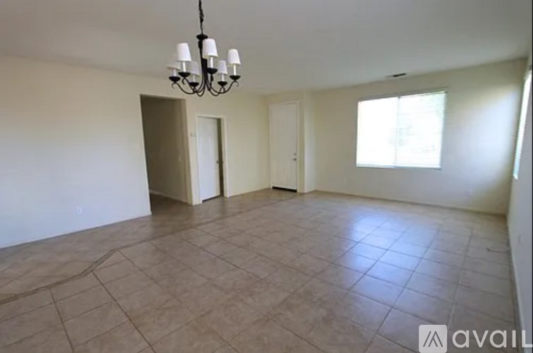 A room with a chandelier and tiled flooring is available for rent.