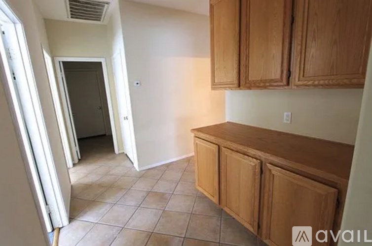 A kitchen with wooden cabinets and a tiled floor.