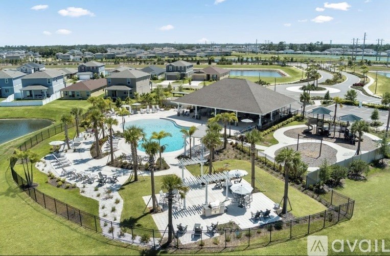 A bird's eye view of a resort with a swimming pool and palm trees.