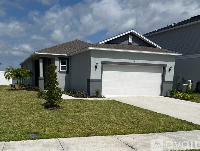 A house with a grey garage door and a brown roof.