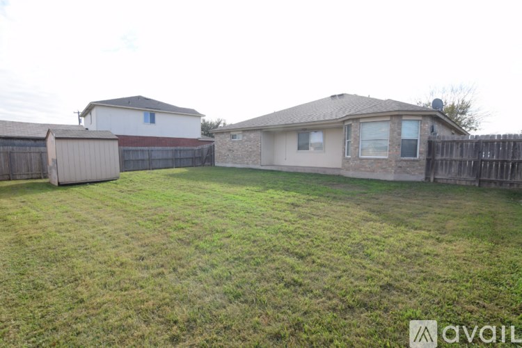 A backyard with a fence and two houses.